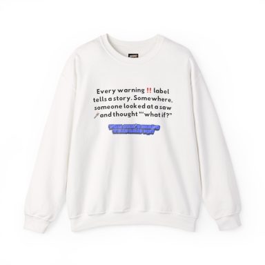 White crewneck sweatshirt featuring black text that reads "Every warning ‼️ label tells a story. Somewhere, someone looked at a saw 🪚 and…